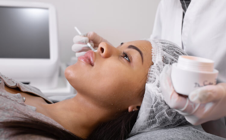 A cosmetology school grad completing a skincare procedure on a client