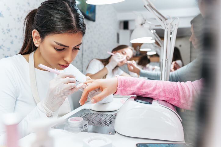 A nail technology program graduate doing a professional manicure