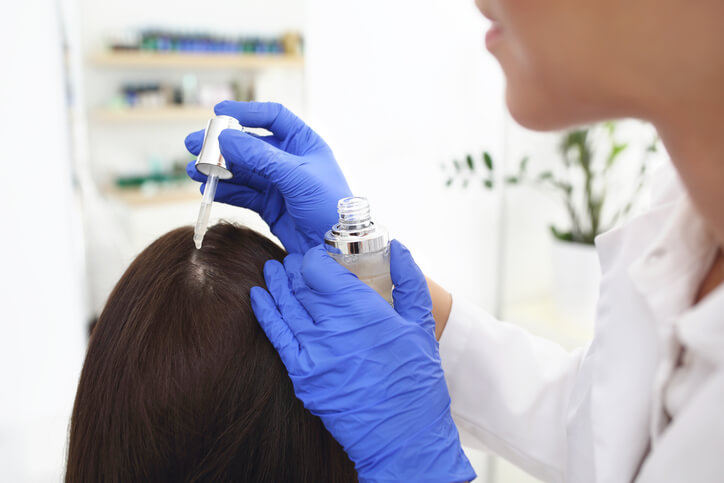 A Korean head spa training grad massaging a client’s scalp