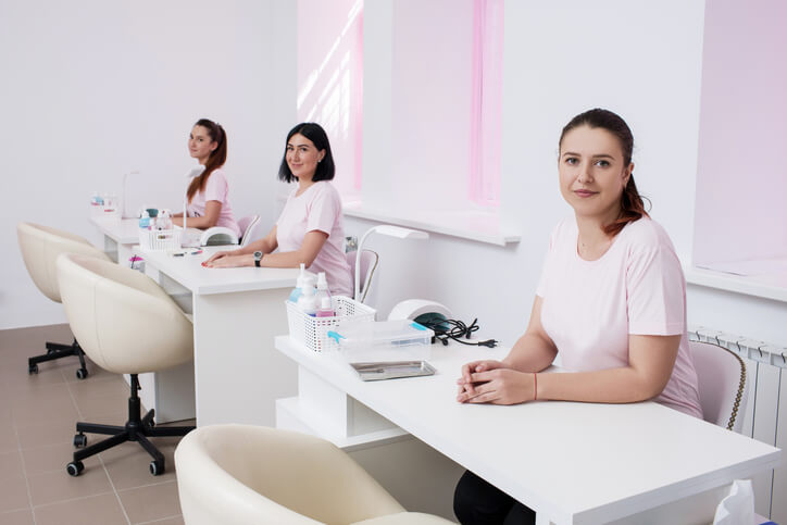 Nail technicians sitting together while owning a beauty salon