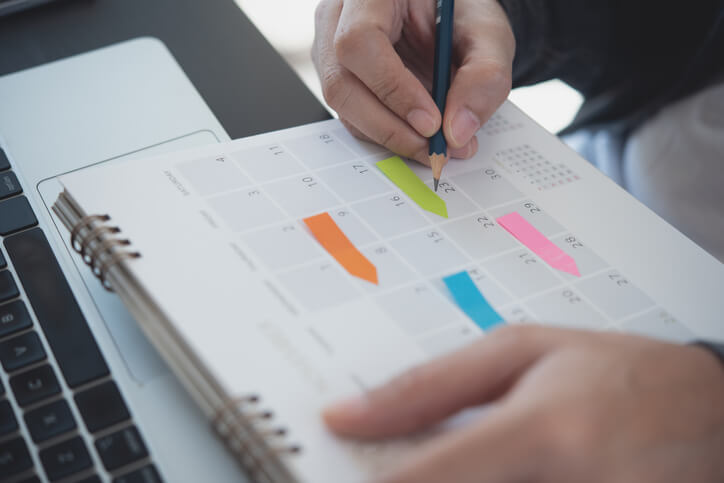 Cosmetology student writing in a color-coded planner