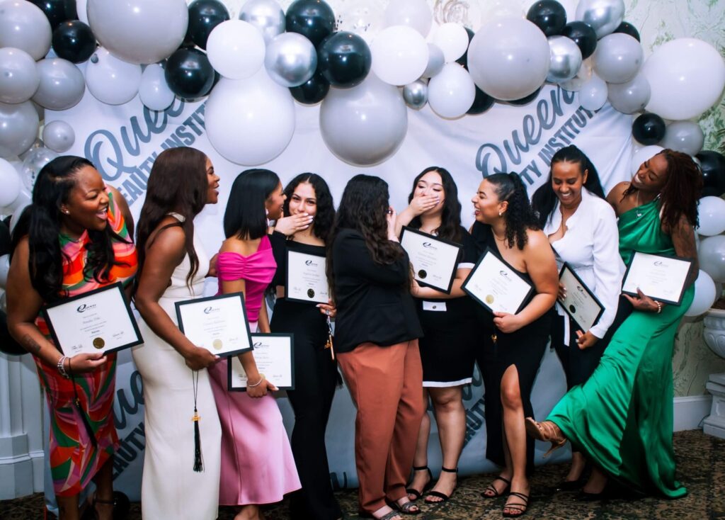 cosmetology school graduates holding diplomas celebrating a ceremony