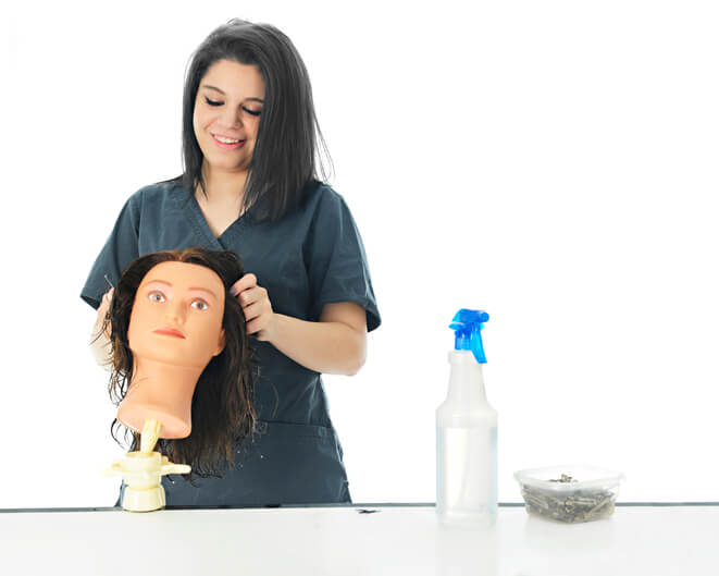 A cosmetology student practicing on a mannequin