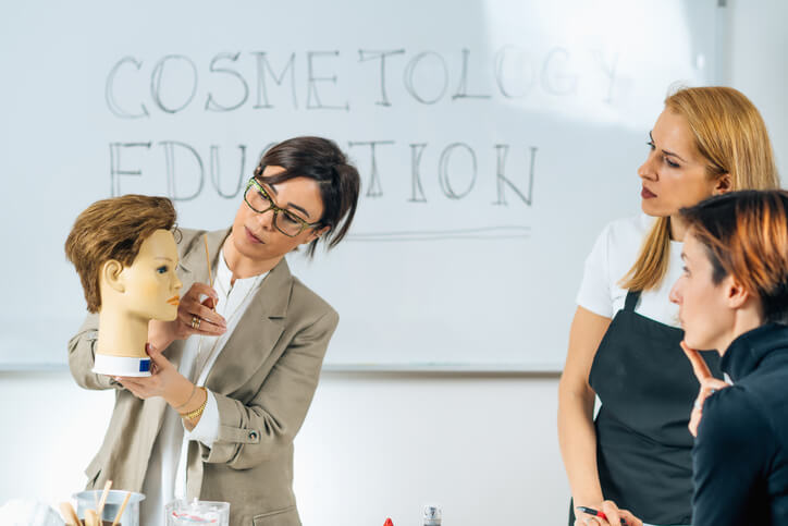A student at our cosmetology school in Philadelphia is working with an instructor